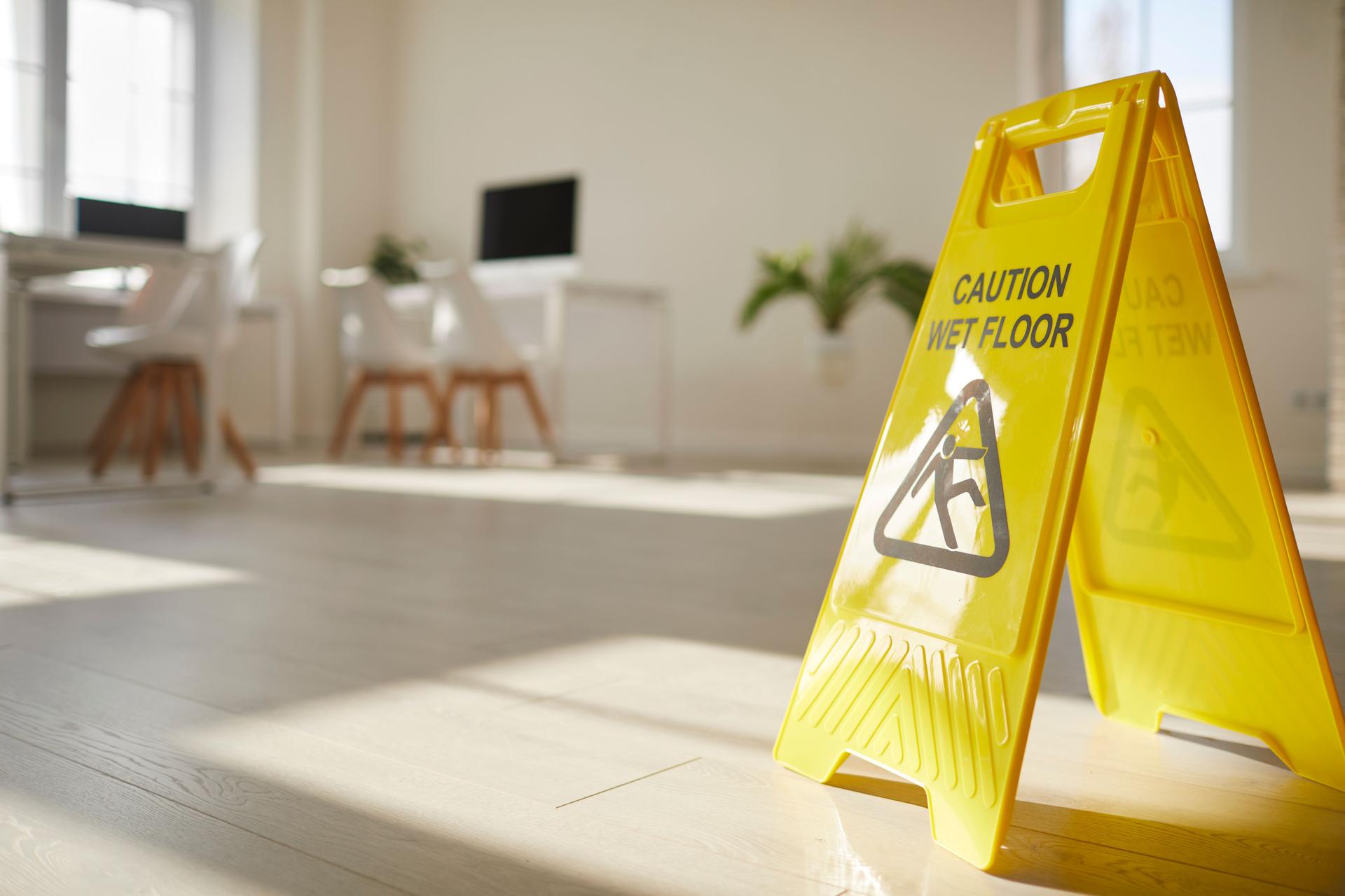 Yellow caution sign of wet floor on surface